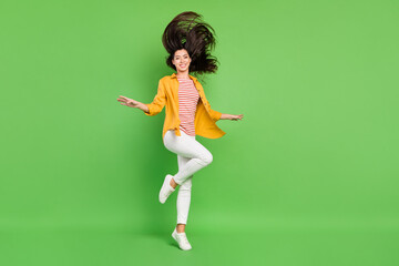Fototapeta na wymiar Photo of pretty adorable young woman dressed casual clothes dancing walking smiling isolated green color background