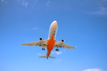 Fototapeta na wymiar Passenger commercial airplane landing against blue cloudy sky.