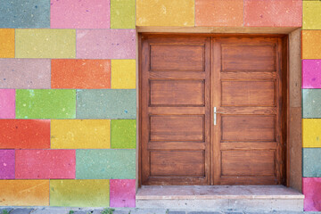 Old vintage brown painted wooden door and colorful painted blocks on wall.