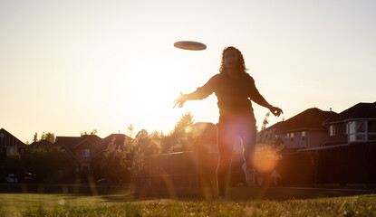 White Caucasian Adult Woman Playing Ultimate Frisbee in the Green Field at neighborhood city park....