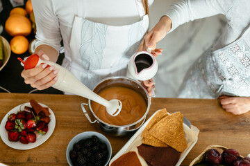 View from above, close up of woman hands cooking homemade fruit marshmallow or berry pastille with knife speaking talking laughing preparing together in kitchen, healthy domestic lifestyle concept.