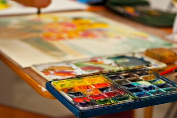 Multicolored paints close up. Watercolor paints on the table.