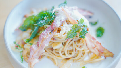 Pasta Carbonara. Spaghetti with bacon, parsel and parmesan cheese. Pasta Carbonara on white plate with parmesan on dark background. Italian food concept.