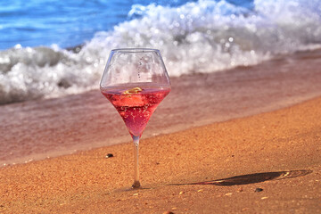 Wine glass with a cocktail by the sea.