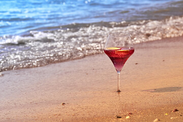 Wine glass with a cocktail by the sea.