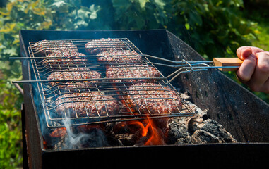 Meat cutlets  for burger on the grill in the fire. Outdoor cooking