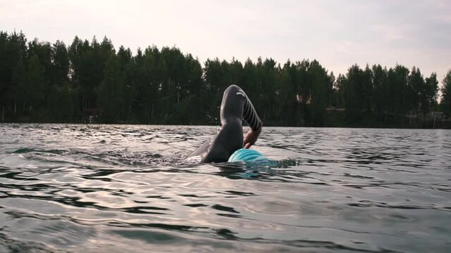 Athletic Young man swimming in wetsuit.  professional triathlon swimmer practicing at morning lake