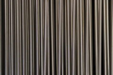 Shiny metal rods arranged in a row.