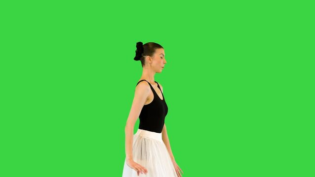 Young ballerina runs slowly making arms movements on a Green Screen, Chroma Key.