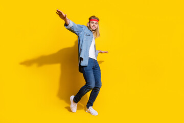Fototapeta na wymiar Photo of funny cute young guy dressed denim shirt smiling dancing isolated yellow color background