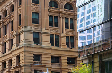Cityscape with a historic refurbished sandstone multi storey building. A high rise building...
