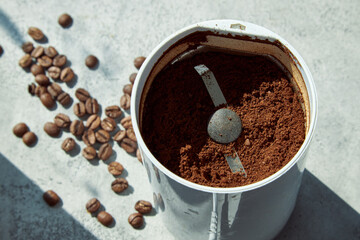Coffee grinder with crushed coffee in sunlight