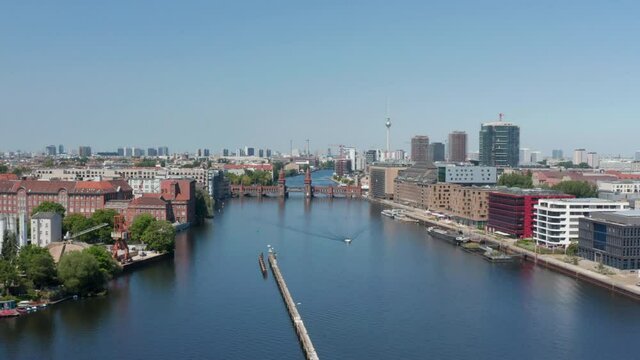 Forwards reveal of double-deck Oberbaum bridge. Old bridge over Spree river. Cityscape with Fernsehturm in background. Berlin, Germany