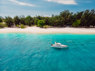 Fototapeta na wymiar Tropical island with sandy beach, motor boat and ocean. Aerial view.