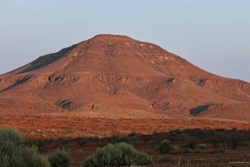 Fototapeta na wymiar stunning red landscape in the semi desert of namibia, blue sky