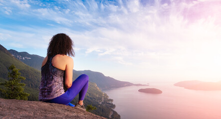Adventurous Caucasian Adult Woman hiking on top of a mountain during a colorful sunny summer...