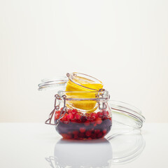 Immune boosting concept. Honey fermentation of fruits and berries. Food composition with glass jars with fermented honey cranberries and lemon on a white background. Homemade remedy for immunity