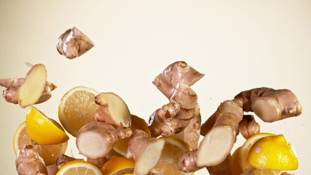 Super slow motion of cut ginger roots flying in the air on gradient background. Filmed on high speed cinema camera, 1000 fps.