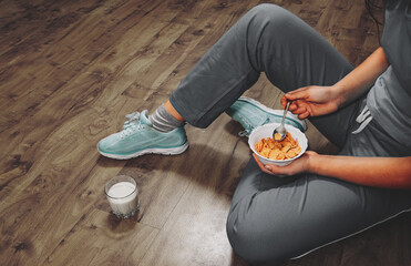 Woman sitting on the floor with healthy breakfast top view