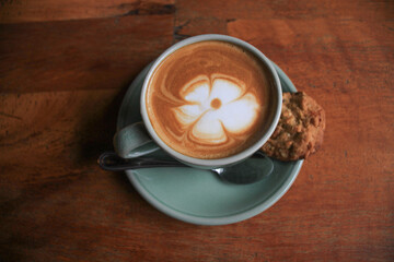 Latte arts coffe hot coffee on wooden table.barista flower art concept.