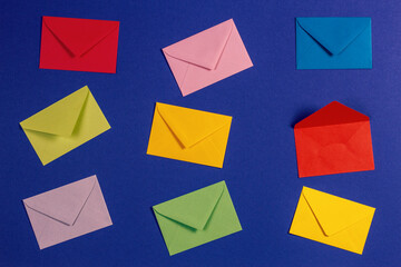 Top view to colorful envelopes displayed on blue background, top view