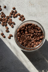 Glass jar with coffee beans on a concrete gray table, top view