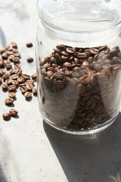 Glass jar with coffee beans in sun light,close up.