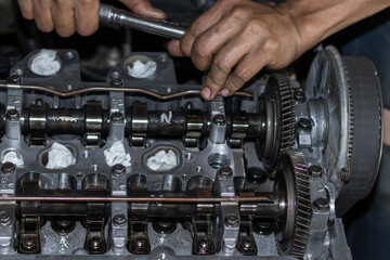 The mechanic is checking the engine.