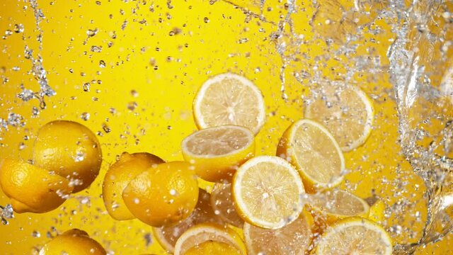 Super slow motion of sliced fresh lemons with water splash flying in the air. Filmed on high speed cinema camera, 1000 fps.