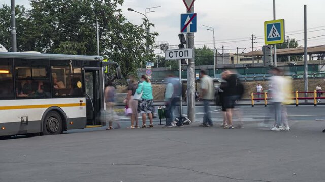 passengers in the queue for boarding the bus on a busy street at the end of the day, time lapse