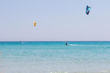 July 23, 2021: boys practicing kitesurfing in the crystal sea near the beach of La Cinta, Sardinia