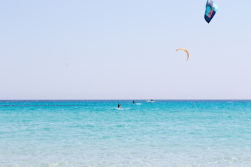 July 23, 2021: boys practicing kitesurfing in the crystal sea near the beach of La Cinta, Sardinia