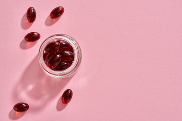 Krill oil pills on a pink background - healthy nutritional supplement
