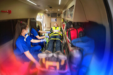 First aid training to transfer patient, loss of feeling or loss of normal movement. Paramedic team transfer man on ambulance stretcher into emergency car. © VStudio