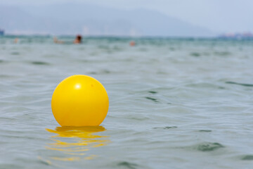 Close up of yellow beach ball floating on the water.