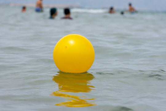 Close Up Of Yellow Beach Ball Floating On The Water.