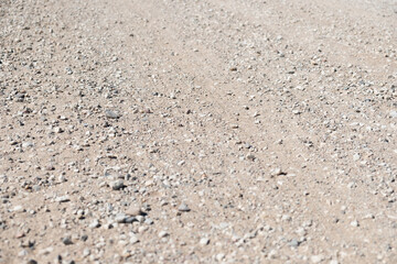 Gravel road background. Old pebble rock countryside road during summer. Empty copy space.