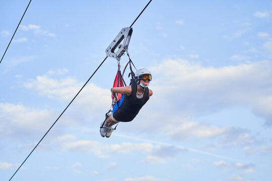 Unrecognizable woman on zip line over mountains
