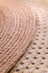The brim of two sun hats (one made of natural fibers, the other made of artificial) one on top of the other as an illustration of the story of the ending summer and diversity. Selective focus. 