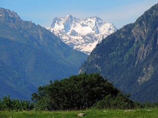 Caucasus Mountains in summer. Snow capped mountains, blue sky on a clear day. 