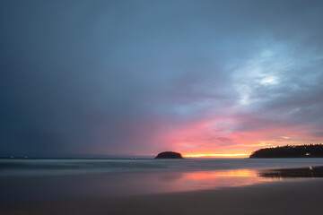 beautiful sunset behind Pu island at Kata beach Phuket. a lot of tourists relax on the beach during sunset..