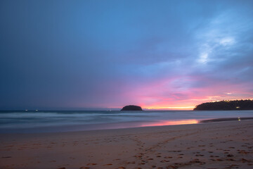 Fototapeta premium beautiful sunset behind Pu island at Kata beach Phuket. a lot of tourists relax on the beach during sunset..