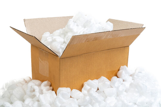 Closeup white polystyrene foam in parcel box. Polystyrene foam cushioning material for packaging, A cardboard box with packing styro foam pellets side view.
