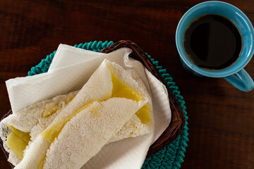 Duas tapiocas recheadas com mussarela e uma xícara de café.