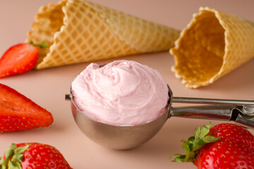 Fresh strawberries and waffle cones on a pink background. Cold summer natural dessert. Strawberry ice cream in a special spoon.