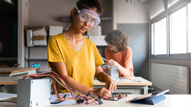 Teen asian girl high school student in class learning electronics looking at camera. Horizontal banner image. Copy space.
