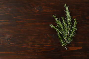 Fresh rosemary bound on brown  wooden board. Healthy organic concept. Aroma herb for cooking