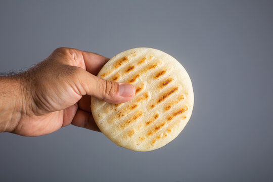 Man holds traditional Venezuelan food arepa made from cornmeal