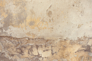 Old cracked weathered painted wall background texture. Dirty peeled plaster wall with falling off flakes of paint