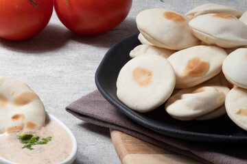 Pile of Pita bread served with sauce.